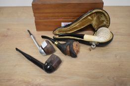 A box containing 4 assorted tobacco pipes, to include a early 20th century hand carved pipe