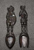 A pair of mid 20th century large fork and spoon plaques, modelled as medieval knights, hand carved