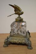 A Victorian cast brass and glass ink well, mounted on an exuberant base having paw feet and stylised