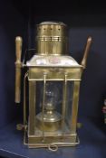 A vintage brass nautical cargo oil lantern with glass chimney, manufactured by Shepperton of