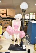 A large mid-century Marilyn Monroe 'flying skirt' lamp, wearing a pink dress, standing on a two tier
