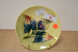 A mid-20th century Moorcroft pottery miniature pin dish, tube lined with dark green foliage on a