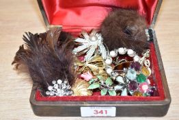 A faux leather jewellery box, containing a selection of brooches, including feather and fur