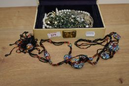 A cream faux leather jewellery box, containing a small collection of costume jewellery including