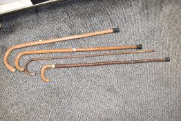 Four late 19th / early 20th century wooden walking sticks, to include a bamboo silver mounted stick,