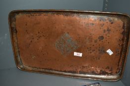 After Hugh Wallis (1871-1943), An Arts & Crafts copper serving tray, hand worked with a floral motif