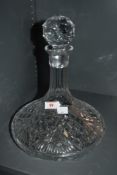 A cut crystal ships decanter, the large bulbous base joining a narrow neck with crystal ball