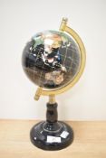 A small table top globe, the countries and continents inlaid with semi precious stones, mounted on a