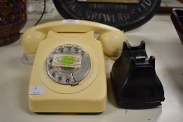 A retro beige plug in telephone having a rotary dial and coiled cable, w19cm.