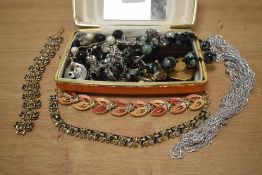 An orange faux leather jewellery box, containing a small collection of costume jewellery,