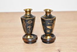 A pair of miniature Egyptian curio urn vases, decorated having gold coloured pharaohs on a black
