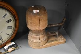 An early 20th century mechanical wooden hat stretcher, having working metal handle allowing the