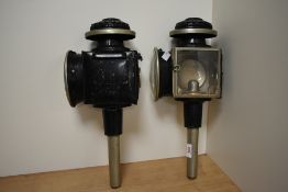 A pair of late 19th / early 20th century brass and black painted carriage lamps, having red eye