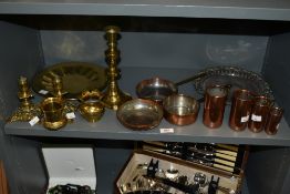 A set of early 20th century graduated polished copper measuring cups with a rolled top and