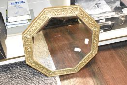 A pretty vintage hexagonal mirror, having bevelled edge glass and a hand embossed frame, W44cm.