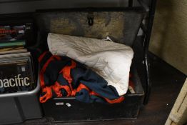 A vintage metal box holding a range of horse jackets, belts, straps, shoes ect