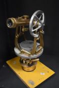 An early 20th century part brass surveyors Theodolite instrument, mounted on a yellow coloured