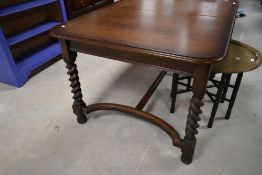 An early 20th Century oak dining table having H stretcher and twist legs supports, approx. 133 x