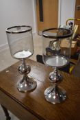 A pair of modern decorative chromed candle holders