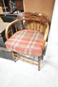 A late 19th or early 20th Century oak spindle back office chair having later tweed upholstered