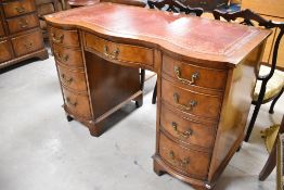 A reproduction yew wood writing desk having serpentine front, width approx. 115cm
