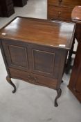 An early 20th Century mahogany sewing cabinet having lift lid section over drawer, on cabriole legs,