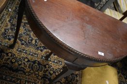An early 20th Century mahogany demi lune fold over card table having gadrooned edge and cabriole