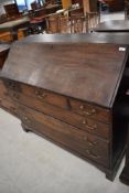 A Georgian mahogany bureau having fitted interior including faux book bindings concealing hidden