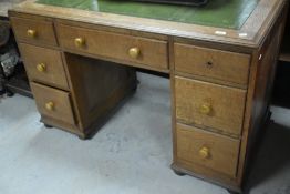 An early 20th Century golden oak desk having inset leather top, approx. 122 x 61cm