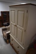 A modern painted wardrobe with pine detailing, having railed section over two short and one long