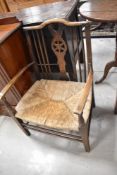 A 19th Century spindle back carver chair having rush seat
