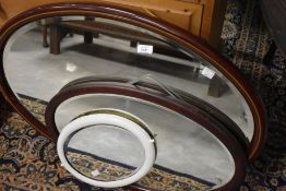 Three assorted oval wall mirrors