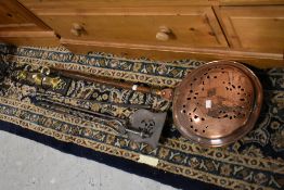 A selection of vintage fire tools, copper warming pan etc