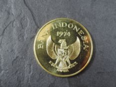A 1974 Bank of Indonesia 100,000 Rupiah Gold Coin, Kamodo Dragon to reverse, Uncirculated in plastic