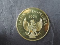 A 1974 Bank of Indonesia 100,000 Rupiah Gold Coin, Kamodo Dragon to reverse, Uncirculated in plastic