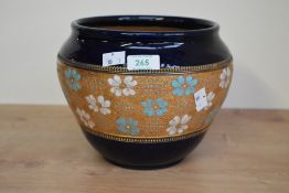 A Royal Doulton stoneware jardinière having a central panel decorated with foliage and gold colour