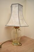 A mid- century modern oval crystal and brass table lamp with marble effect shade, the glass having