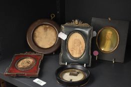 A 19th century miniature portrait of a gentleman mounted behind a gilt oval surround borded within a