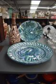 Two large 20th century Spanish terracotta plates, vibrantly hand coloured with exotic bird and