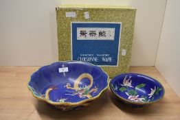 An early 20th century Cloisonne enamel bowl, decorated with clawed dragon's on a blue ground, w26cm,