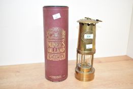 An early 20th century Cumbrian miner's oil lamp with presentation case, impressed number 287431