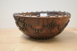 An early 20th century wooden fruit or mixing bowl, decorated with studwork and one penny pieces,