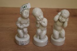 A set of three white Bing & Grondahl Copenhagen porcelain baby figures, each depicting exaggerated