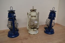 A vintage metal Swallow oil lantern in cream colour, h26cm, sold together with two other blue oil
