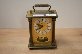 A small brass 8 day anniversary carriage clock, the face flanked by Doric columns, h14cm.