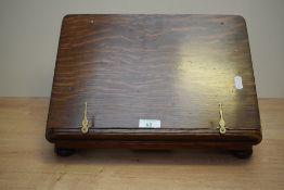 A late 19th century oak bookrest having adjustable back, brass hinges and page holders, supported on