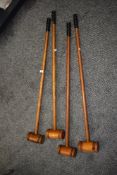 A group of four early 20th century pine croquet mallets in the style of Jacques for Harrods, H95cm.