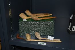 A group of 17th century clay tobacco pipes intricately carved depicting foliage motifs, largest
