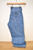 A 1980s-1990s pair of Wrangler denim jeans, having the classic five-pocket design, waist measuring
