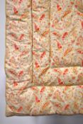 A beautiful Eiderdown quilt, pale yellow-green with pink and red floral paisley pattern, having